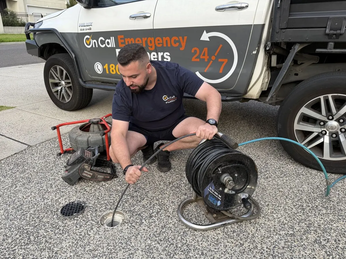 Plumber preparing drain clearing equipment, Highett